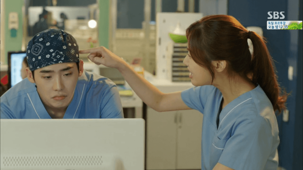 Oh Soo-Hyun points a finger at Park Hoon's hair while he looks at a computer