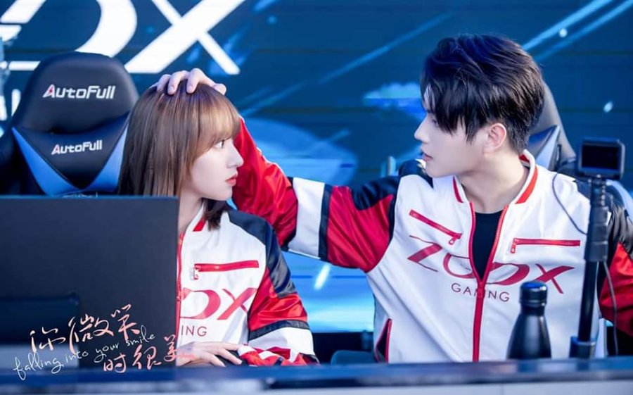 still from falling into your smile where Lu Si Cheng puts his hand on Tong Yao's head as they look at each other after a game